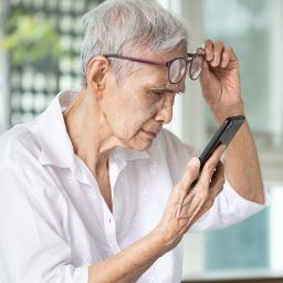 woman looking at her phone with cataracts
