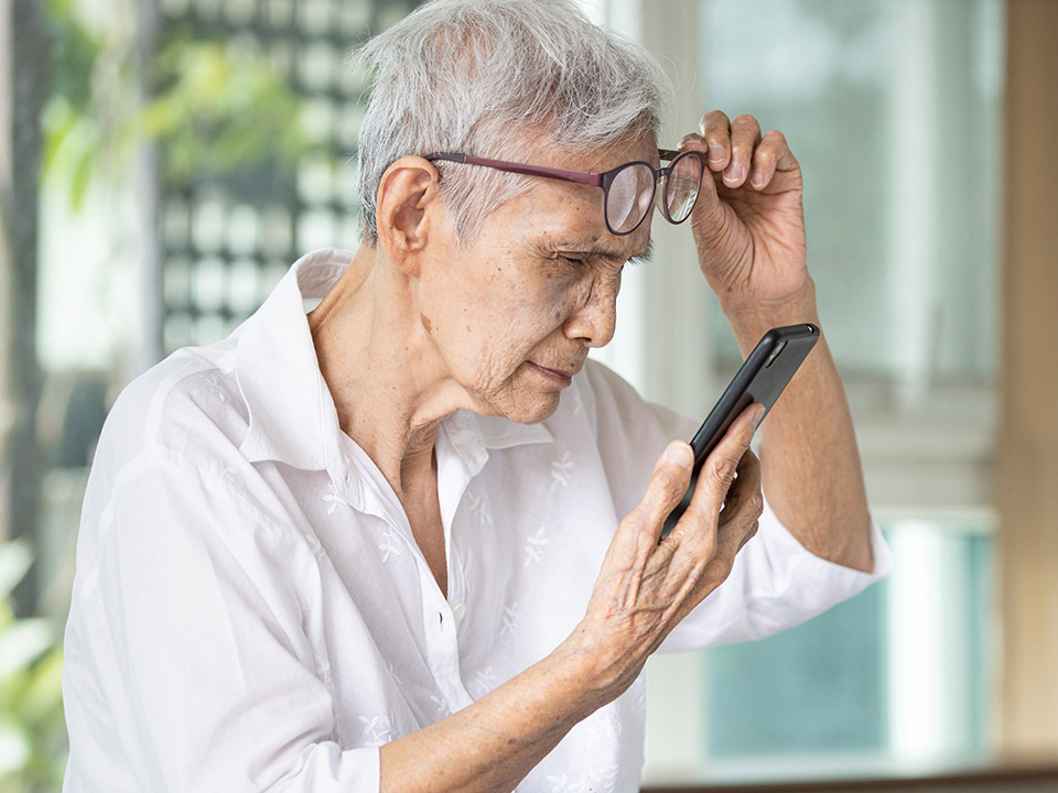 woman looking at her phone with cataracts