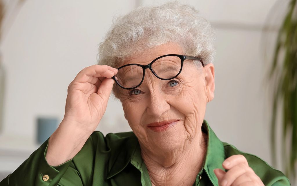 happy senior woman taking glasses off