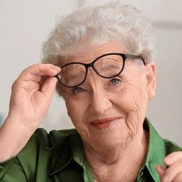 happy senior woman taking glasses off