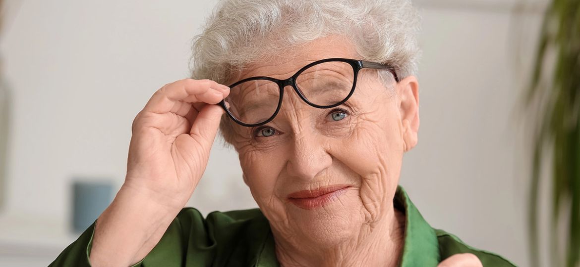 happy senior woman taking glasses off