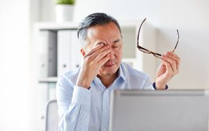 man rubbing his eyes