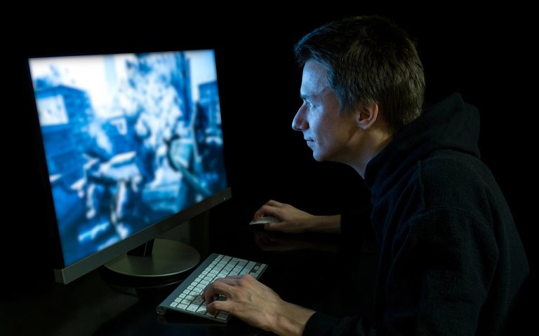 man playing video games on computer
