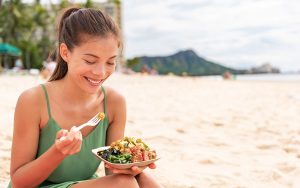 woman at the beach eating healthy