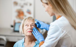 doctor applying eye drops to patient