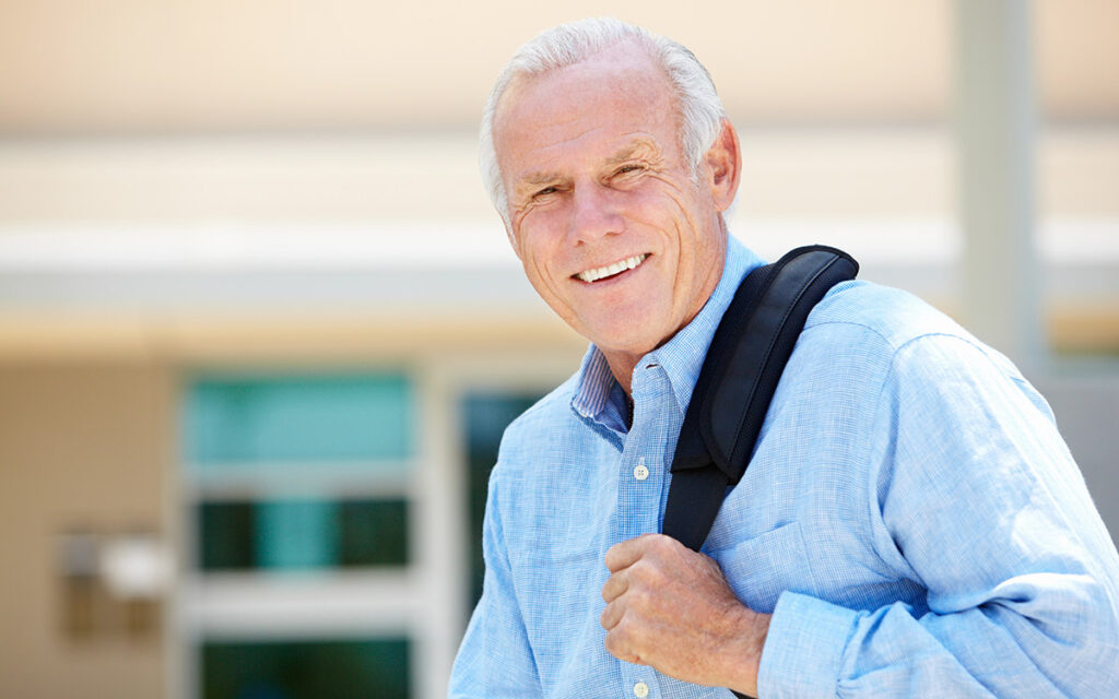 senior man smiling with a backpack